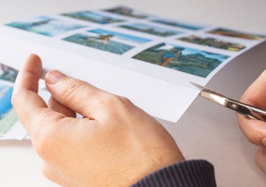 Bir adam yakın planda insanlarla fotoğraf çeker. Bir adam basılı fotoğraf çekmek için makas kullanır. Albüm için. Bir insan diğer fotoğrafların arka planına karşı elinde bir polaroid fotoğraf tutar..
