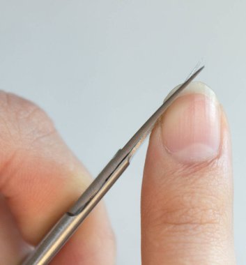 Bir insan tırnaklarını küçük bir makasla keser. Erkek manikürü. Bir adam kocaman bir çiviyi kesiyor.