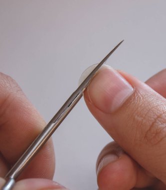 Bir insan tırnaklarını küçük bir makasla keser. Erkek manikürü. Bir adam kocaman bir çiviyi kesiyor.