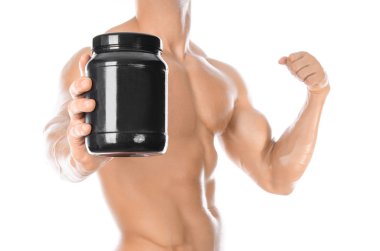 Bodybuilding and Sports theme: handsome strong bodybuilder holding a plastic jar with a dry protein and showing gesture isolated on white background in studio
