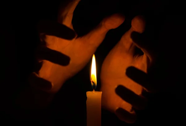 Stava och andlighet ämne: häxor hand som håller ett ljus på en mörk bakgrund — Stockfoto