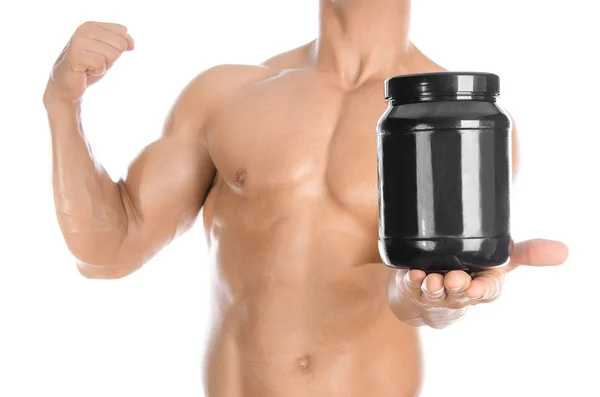 Carrosserie et sport thème : beau bodybuilder fort tenant un pot en plastique avec une protéine sèche et montrant geste isolé sur fond blanc en studio — Photo