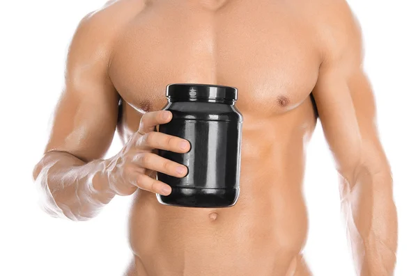 Bodybuilding and Sports theme: handsome strong bodybuilder holding a plastic jar with a dry protein and showing gesture isolated on white background in studio — Stockfoto