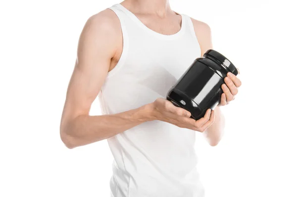 Bodybuilding and Sports theme: a thin man in a white T-shirt and jeans holding a plastic jar with a protein isolated on a white background in studio — Stockfoto