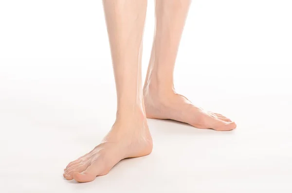 Pedicure and foot care topic: the naked man's legs isolated on white background in studio — Stock Photo, Image