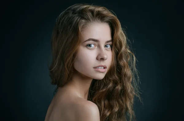 Retrato dramático de um tema de menina: retrato de uma menina bonita com cabelo voando no vento contra um fundo no estúdio — Fotografia de Stock