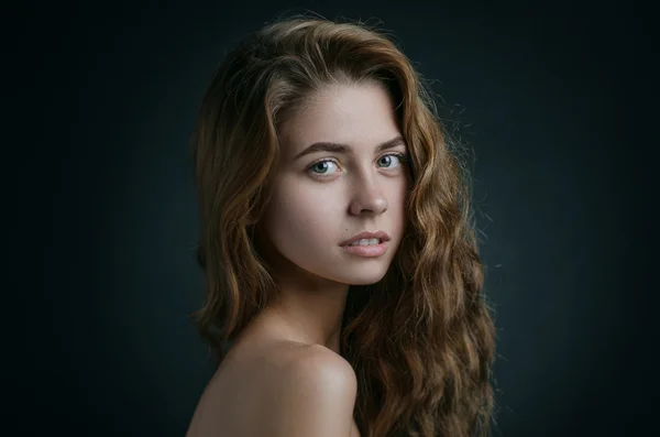 Retrato dramático de um tema de menina: retrato de uma menina bonita com cabelo voando no vento contra um fundo no estúdio — Fotografia de Stock