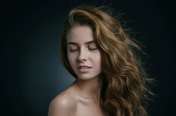 Retrato dramático de um tema de menina: retrato de uma menina bonita com cabelo voando no vento contra um fundo no estúdio — Fotografia de Stock