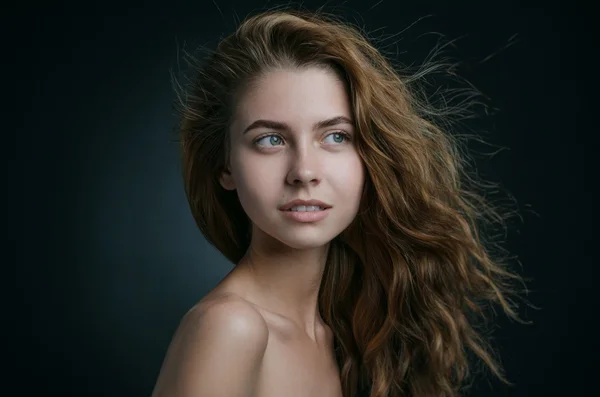 Retrato dramático del tema de una chica: retrato de una hermosa chica con el pelo volando en el viento sobre un fondo en el estudio —  Fotos de Stock