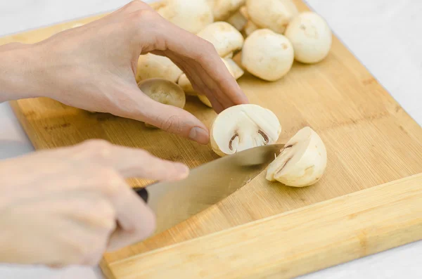 Champignons et nourriture thème : homme préparant des cèpes sur une planche de bois sur un fond d'herbe verte en été — Photo