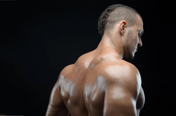 Bodybuilder and strip theme: beautiful with pumped muscles naked man posing in the studio on a dark background — Stock Photo, Image