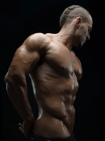 Bodybuilder und Strip-Thema: Schön mit gepumpten Muskeln, nackter Mann posiert im Studio vor dunklem Hintergrund — Stockfoto