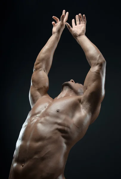 Bodybuilder and strip theme: beautiful with pumped muscles naked man posing in the studio on a dark background — Stock Photo, Image