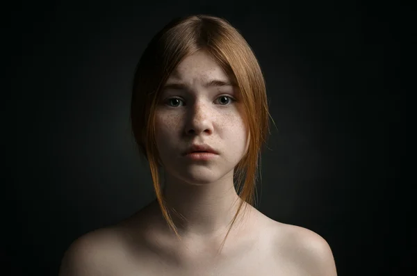 Dramatic portrait of a girl theme: portrait of a beautiful girl on a background in the studio