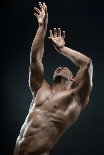 Bodybuilder and strip theme: beautiful with pumped muscles naked man posing in the studio on a dark background — Stock Photo, Image