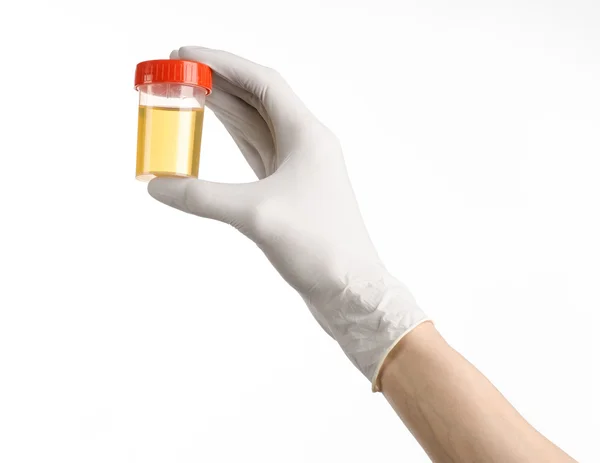 Medical theme: doctor's hand in white gloves holding a transparent container with the analysis of urine on a white background — Stock Photo, Image