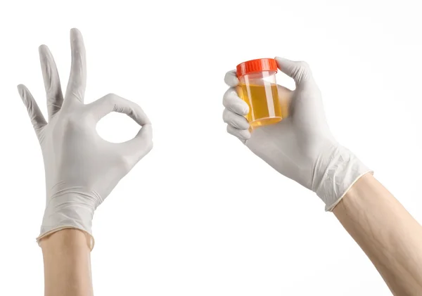 Medical theme: doctor's hand in white gloves holding a transparent container with the analysis of urine on a white background — Stock Photo, Image