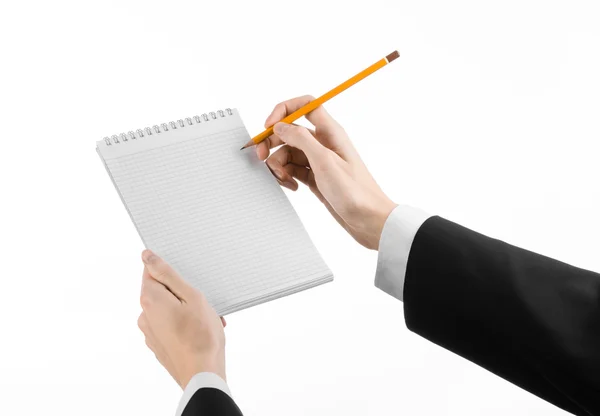 Тема бізнесу та репортера: рука журналіста в чорному костюмі, який тримає блокнот з олівцем на білому тлі ізольовано — стокове фото