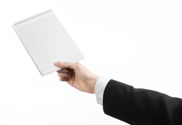 Tópico de negócios e repórter: a mão de um jornalista em um terno preto segurando um caderno com um lápis em um fundo branco isolado — Fotografia de Stock