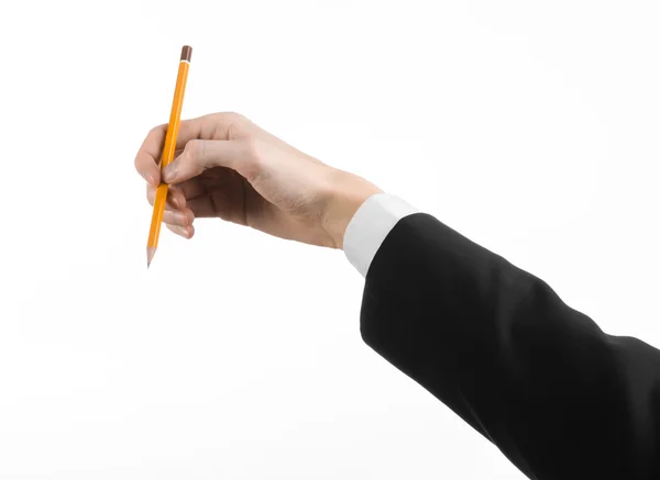 Tema Disegno e Design: la mano dell'artista in abito nero con una matita isolata su sfondo bianco in studio — Foto Stock