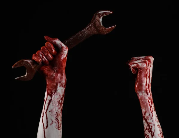 Кровавая рука держит большой гаечный ключ, кровавый гаечный ключ, большой ключ, кровавая тема, Хэллоуин тема, сумасшедший механик, убийца, психопат, насилие, зомби, черный фон, изолированные, революция — стоковое фото