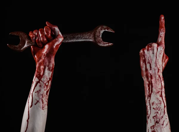 Blodiga handen håller en stor skiftnyckel, blodiga skiftnyckel, big key, blodiga tema, halloween-tema, crazy mekaniker, mördare, psycho, våld, zombies, svart bakgrund, isolerad, revolution — Stockfoto