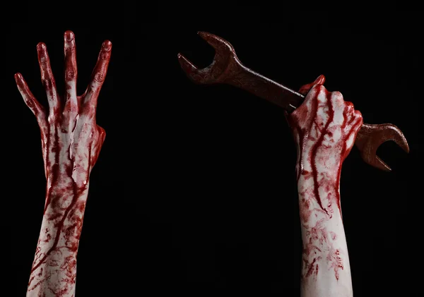 Blutige Hand mit großem Schraubenschlüssel, blutigem Schraubenschlüssel, großem Schlüssel, blutigem Thema, Halloween-Thema, verrücktem Mechaniker, Mörder, Psycho, Gewalt, Zombies, schwarzem Hintergrund, isoliert, Revolution — Stockfoto