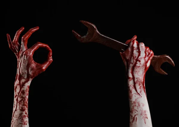 Кровавая рука держит большой гаечный ключ, кровавый гаечный ключ, большой ключ, кровавая тема, Хэллоуин тема, сумасшедший механик, убийца, психопат, насилие, зомби, черный фон, изолированные, революция — стоковое фото