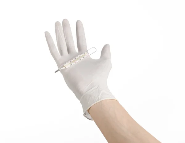 Tema médico: Mano del médico con guantes blancos sosteniendo un termómetro para medir la temperatura del paciente sobre un fondo blanco —  Fotos de Stock