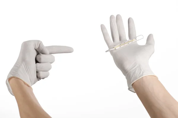 Tema médico: mão de médico em luvas brancas segurando um termômetro para medir a temperatura do paciente em um fundo branco — Fotografia de Stock