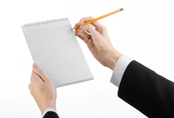 Affärs- och reporter ämne: handen av en journalist i svart dräkt innehar en anteckningsbok med en penna på en vit bakgrund isolerade Stockfoto