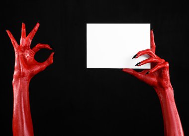 Halloween Tema: kırmızı şeytan el siyah çivi siyah bir arka plan üzerinde boş bir beyaz kart tutan