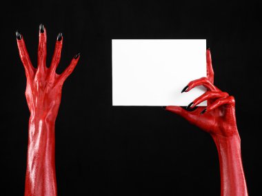 Halloween Tema: kırmızı şeytan el siyah çivi siyah bir arka plan üzerinde boş bir beyaz kart tutan