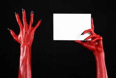 Halloween Tema: kırmızı şeytan el siyah çivi siyah bir arka plan üzerinde boş bir beyaz kart tutan