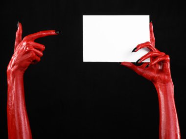 Halloween Tema: kırmızı şeytan el siyah çivi siyah bir arka plan üzerinde boş bir beyaz kart tutan
