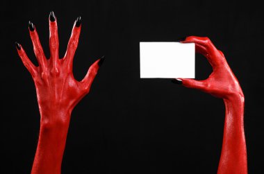 Halloween Tema: kırmızı şeytan el siyah çivi siyah bir arka plan üzerinde boş bir beyaz kart tutan