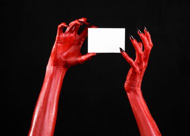 Halloween Tema: kırmızı şeytan el siyah çivi siyah bir arka plan üzerinde boş bir beyaz kart tutan