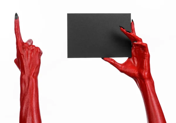 Tema de Halloween: Mano roja del diablo con clavos negros sosteniendo una tarjeta negra en blanco sobre un fondo blanco — Foto de Stock