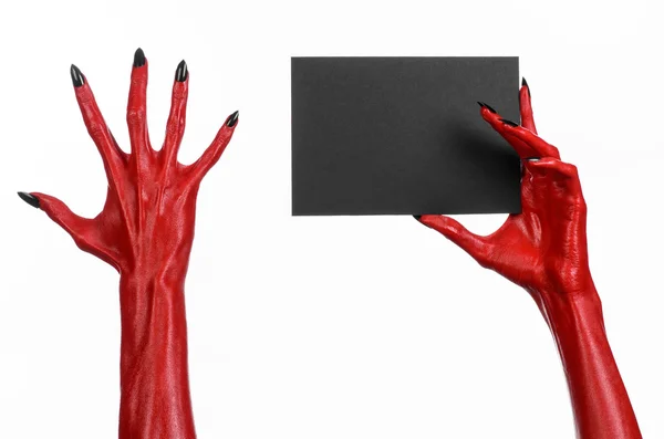 Tema de Halloween: Mano roja del diablo con clavos negros sosteniendo una tarjeta negra en blanco sobre un fondo blanco — Foto de Stock