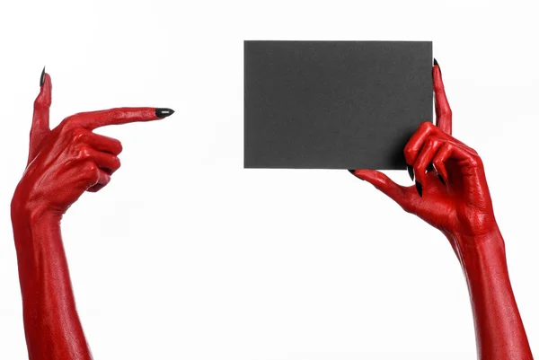 Halloween-Thema: rote Teufelshand mit schwarzen Nägeln, die eine leere schwarze Karte auf weißem Hintergrund halten — Stockfoto
