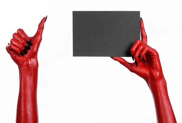 Tema de Halloween: Mano roja del diablo con clavos negros sosteniendo una tarjeta negra en blanco sobre un fondo blanco —  Fotos de Stock