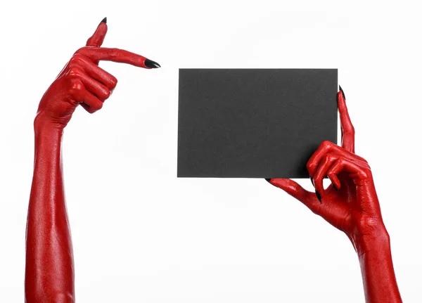 Tema di Halloween: mano del diavolo rosso con chiodi neri in possesso di una carta nera vuota su uno sfondo bianco — Foto Stock