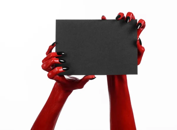 Tema de Halloween: Mano roja del diablo con clavos negros sosteniendo una tarjeta negra en blanco sobre un fondo blanco — Foto de Stock