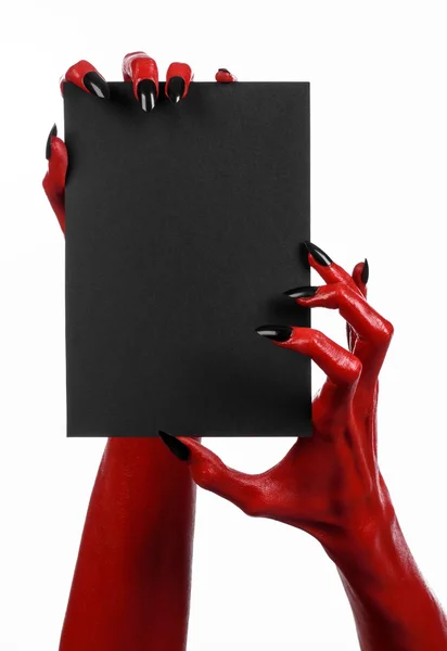 Thème d'Halloween : Main du diable rouge avec des ongles noirs tenant une carte noire vierge sur un fond blanc — Photo