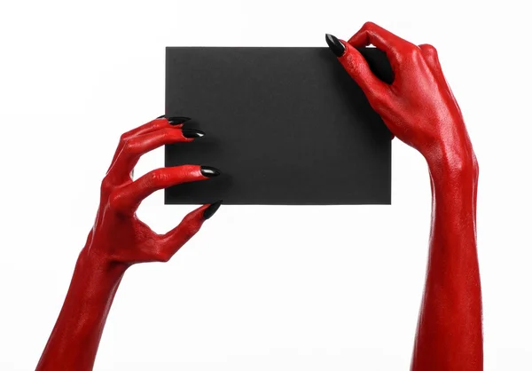 Tema de Halloween: Mano roja del diablo con clavos negros sosteniendo una tarjeta negra en blanco sobre un fondo blanco — Foto de Stock