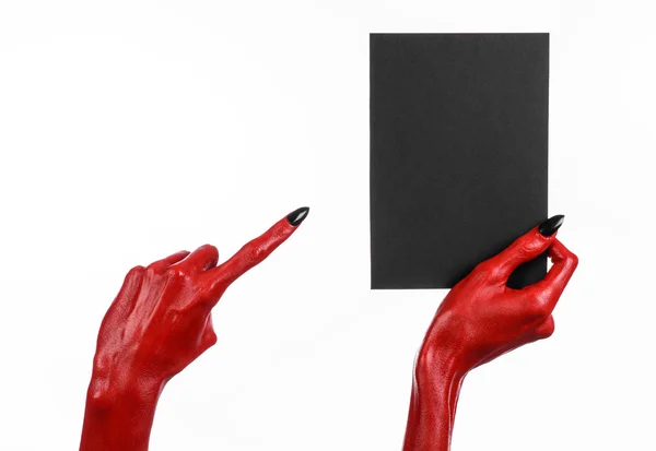 Tema de Halloween: Mão do diabo vermelho com pregos pretos segurando um cartão preto em branco em um fundo branco — Fotografia de Stock