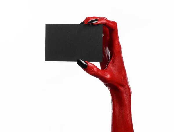 Tema de Halloween: Mano roja del diablo con clavos negros sosteniendo una tarjeta negra en blanco sobre un fondo blanco — Foto de Stock