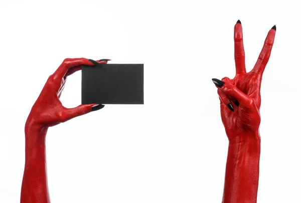 Tema di Halloween: mano del diavolo rosso con chiodi neri in possesso di una carta nera vuota su uno sfondo bianco — Foto Stock