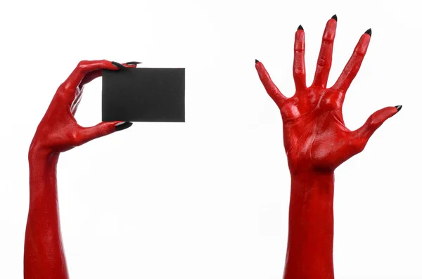 Tema de Halloween: Mano roja del diablo con clavos negros sosteniendo una tarjeta negra en blanco sobre un fondo blanco — Foto de Stock