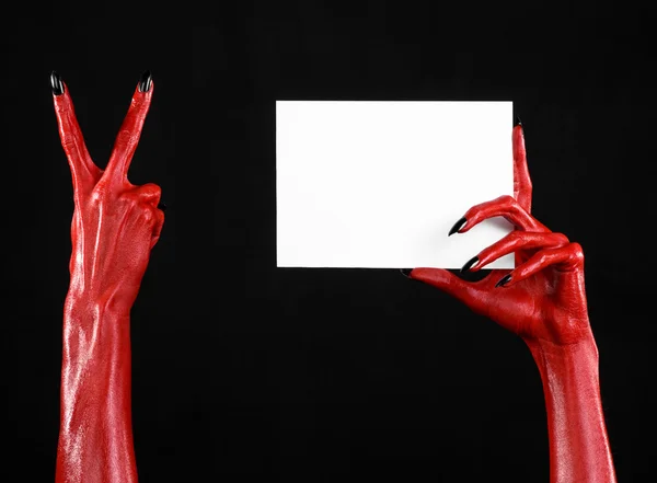 हेलोवीन थीम: काले नाखूनों के साथ लाल शैतान हाथ एक काले पृष्ठभूमि पर एक खाली सफेद कार्ड पकड़े हुए — स्टॉक फ़ोटो, इमेज